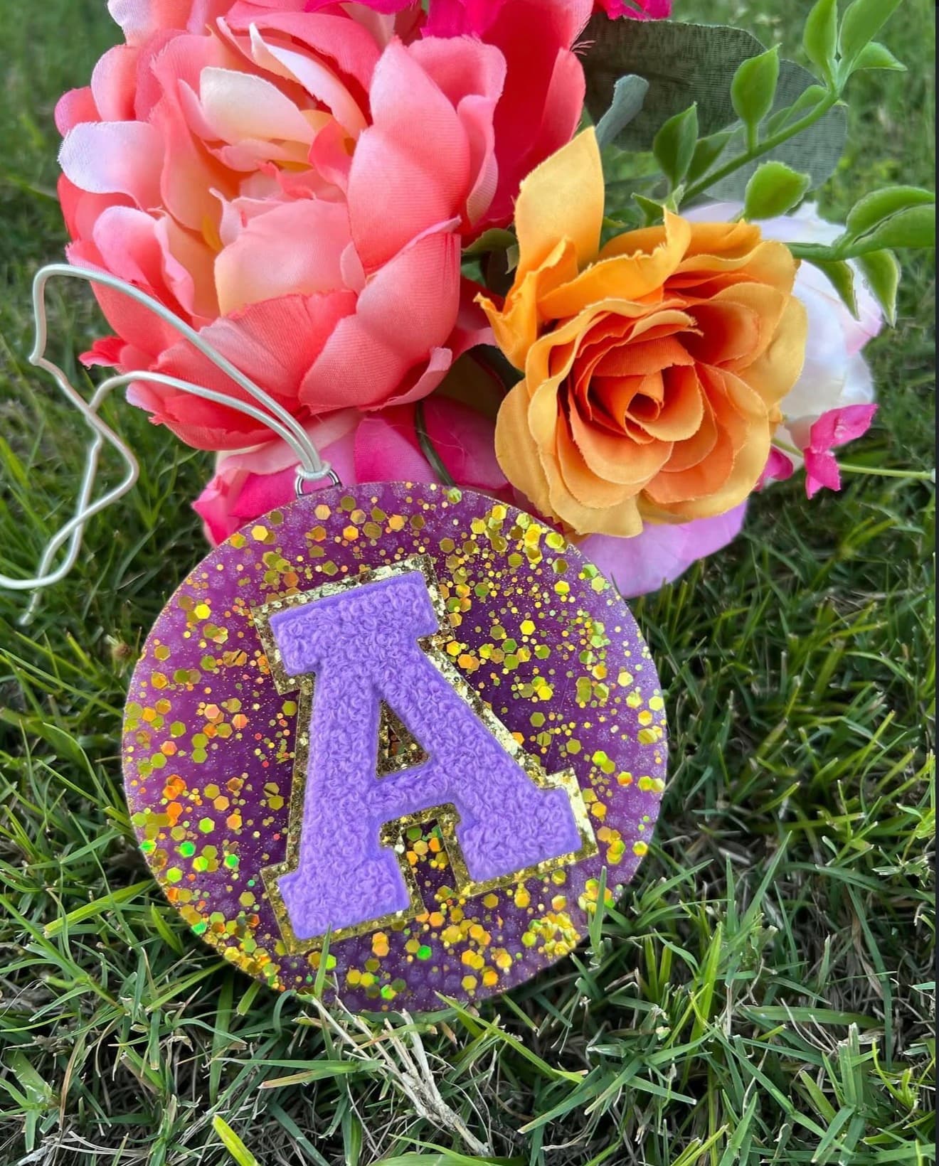 A custom monogram freshie with chenille letter A on purple glitter background with flowers